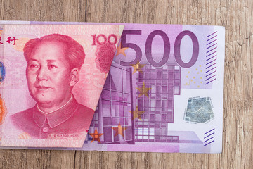 500 euro and 100 yaun bills on desk.