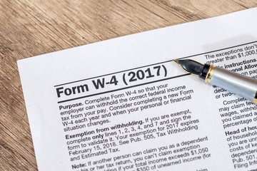 w 4 tax form with pen on desk.