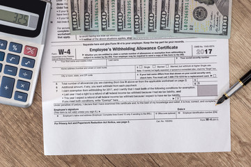 w4 tax form with money and pen.