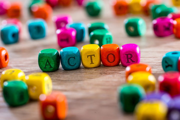actor - word created with colored wooden cubes on desk.