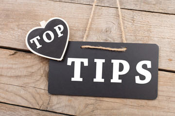 Blackboards with inscription "TOP TIPS" on wooden background