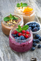 assortment breakfast with fresh berries, fruit and chocolate in glass jars, top view, vertical