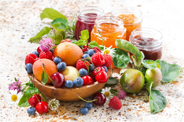 assortment of seasonal fruits and berries, jams on table