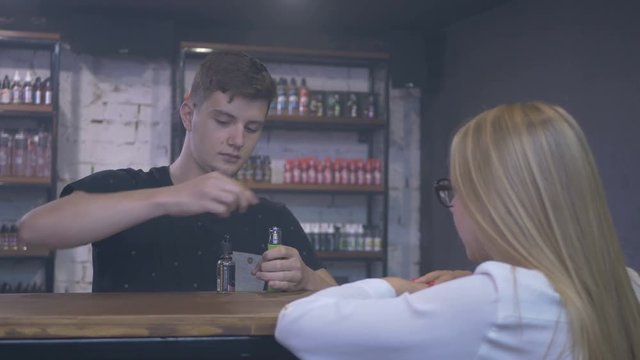 Young guy fill the vape in shop with liquid