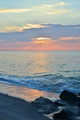 Fototapeta premium Sunrise Over Rock Jetty on the Beach