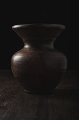 Clay vase on dark wooden background
