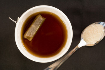 Taza de té y cuchara con azúcar