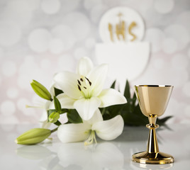 Holy communion a golden chalice with grapes and bread wafers