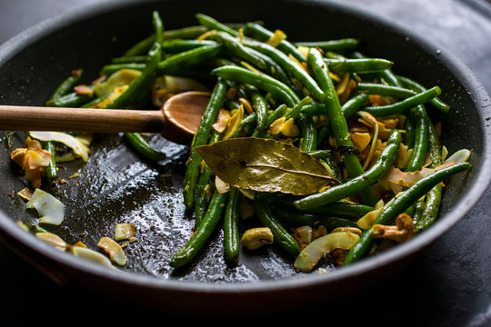 Green beans with coconut chips and mustard seeds, in pan