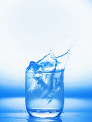 Soft focus of blue tone splash water in a glass