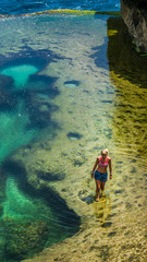 Girl walking in Natural Yellow Pool in Beautiful Cliff Formation, Bizarre Place, Nusa Penida Bali Indonesia