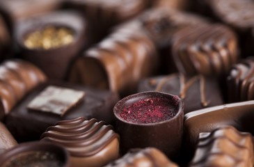 Chocolate bars and pralines on wooden background