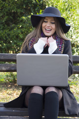 Beautiful young woman looking at laptop