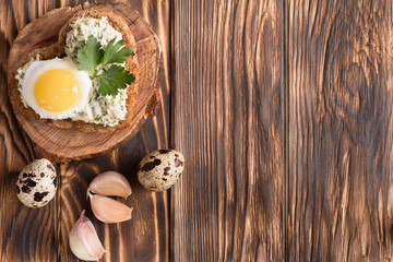 a sandwich in the shape of a heart with egg, cheese, dill, garlic on a wooden table
