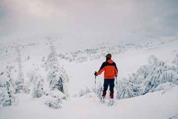 Tourist enjoying beautiful landscape in winter mountain