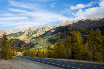 Back road through mountains with changing trees of Colorado