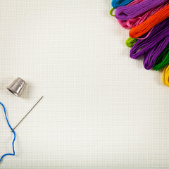 Embroidery Floss Background on a white cloth. Concept for sewing and embroidery. Selective focus.