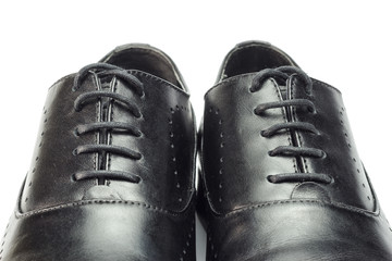 Close-up of classic black leather men's shoes isolated on white background.