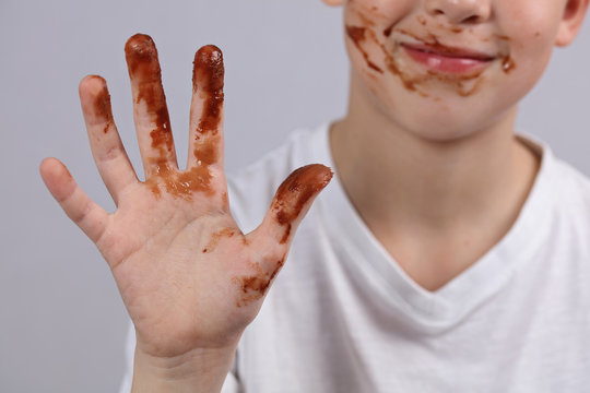 Child Showing Dirty Hands With Stains Of Chocolate