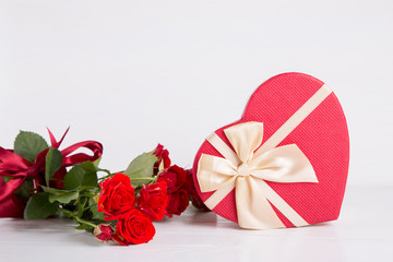 Bouquet of red roses with red gift box on white background