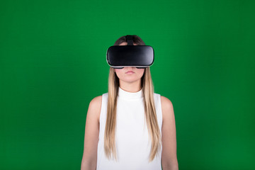 female model in white dress wearing virtual reality headset over green background