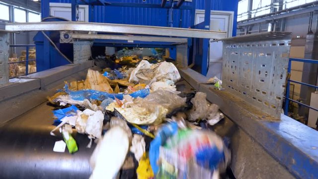 Plastic, cellophane trash on a conveyor at a recycling plant. No people. 4K.