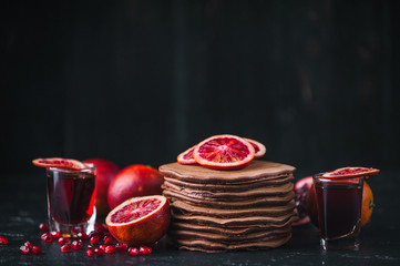 Chocolate Pancake with citrus and pomegranate on a wooden background in rustic style