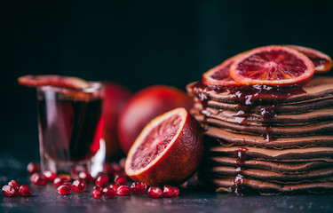 Chocolate Pancake with citrus and pomegranate on a wooden background in rustic style