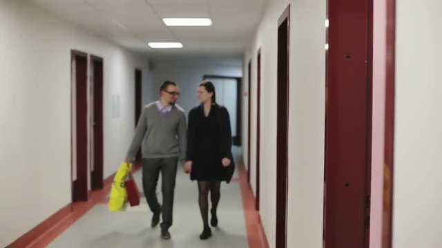 The couple goes a long corridor.