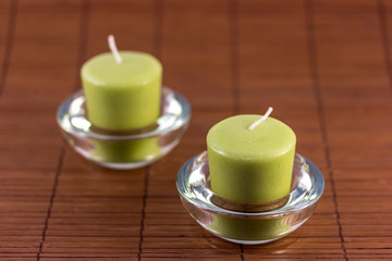 Green candles on wooden mat