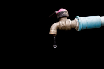 old rusty tap leaking water isolate on black background