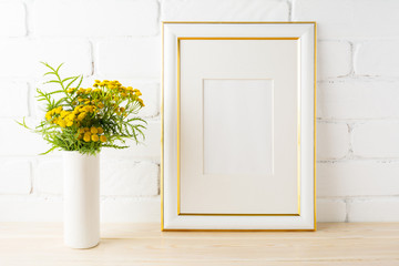 Gold decorated frame mockup  yellow flowers near painted brick walls