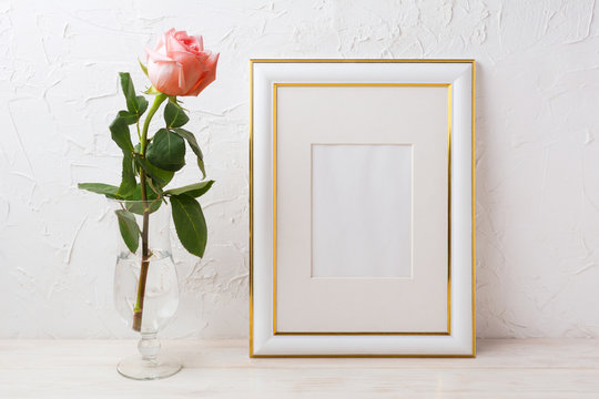 Gold decorated frame mockup with rose in exquisite glass vase