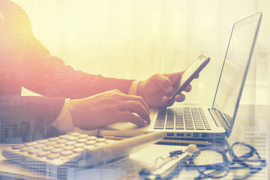 Social network user login,man working from home using smart phone and notebook computer, man's hands using smart phone for writing,man using technology,tablet,smartphone,vintage color,selective focus.