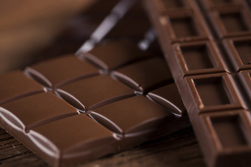 Dark homemade chocolate bars and cocoa pod on wooden