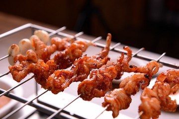 Spicy chicken satay on grill	