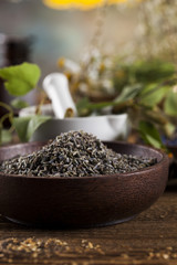 Assorted natural medical herbs and mortar on wooden table background