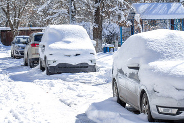 car in the snow after a snowfall in town