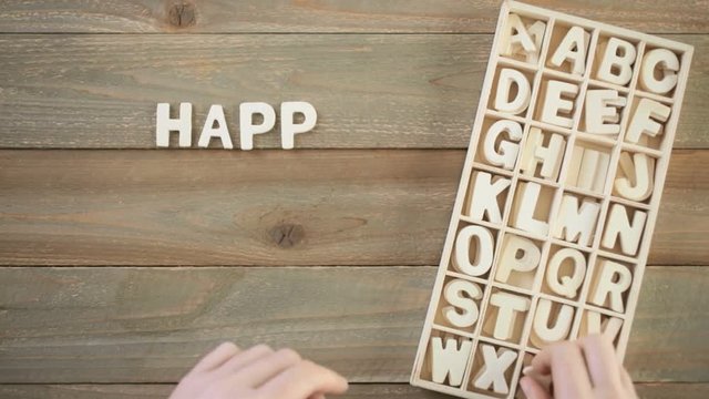 Time-lapse. Unfinished wood letters sign Happy Father's Day on a painted wood background