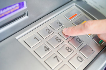 Asian BusinessMan hand is entering number on ATM machine to deposit / withdraw money, Financial Banking Technology Automatic machine Transfers background concept