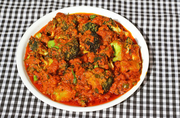 Indian style Broccoli Sabji (spicy broccoli vegetable) in white plate on black and white background.