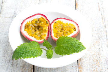 Passion fruit on a white plate with mint