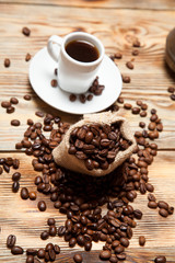 cup of coffee with grains on the wooden background