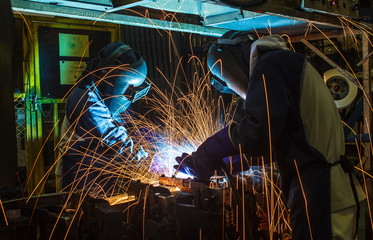 Worker,welding in a car factory with sparks, manufacturing, industry
