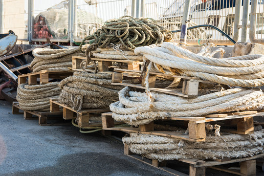 Stack of rolled mooring ropes on wood pallets in a fishing port, boat, nets, Mediterranean sea, Costa Blanca, Spain