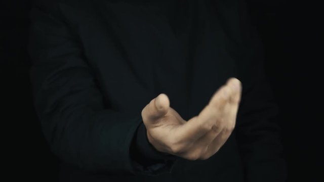 Caucasian male hand in long sleeve jacket impatiently making cash sign gesture rubbing fingers together, get ruble money and count it on black background, close up isolated