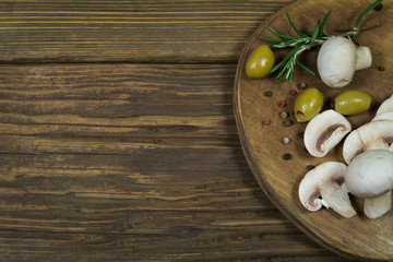 Mushrooms and olives on a wooden board