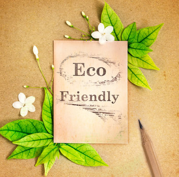 The old blank paper sheet with fresh spring  green leafs border frame on brown recycle paper background , eco natural banner concept