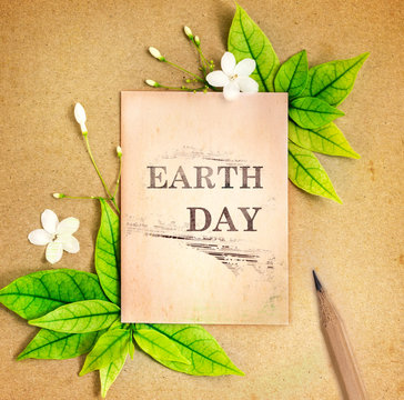 Earth Day paper sheet with fresh spring  green leafs border frame on brown recycle paper background , eco natural banner concept