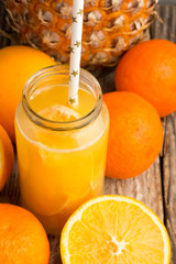 juice in a glass tube butylkes, oranges and pineapple close-up.